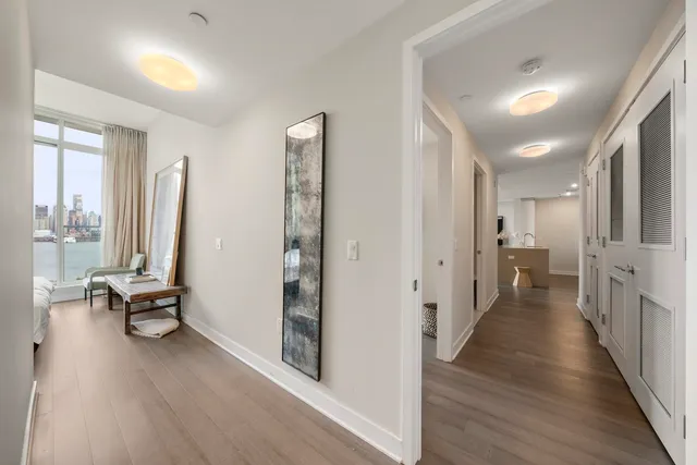 a view of a hallway with wooden floor and windows