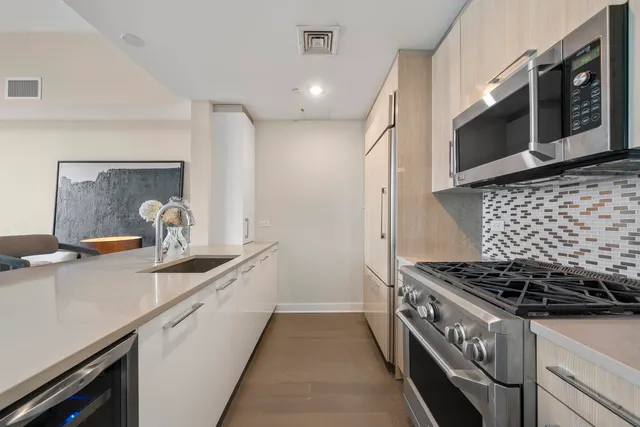 a kitchen with stainless steel appliances granite countertop a sink and a stove