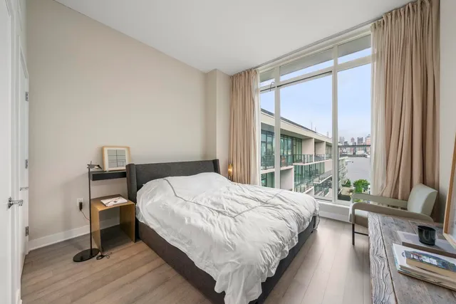 a bedroom with a bed and a large window