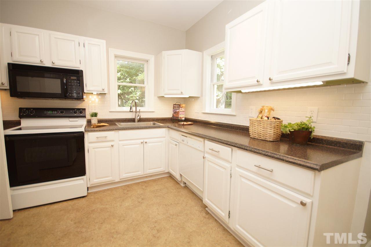 1729 Falls Church Road Raleigh, NC 27609 - Photo 11 of 25 a white kitchen with granite countertop a sink a stove and cabinets