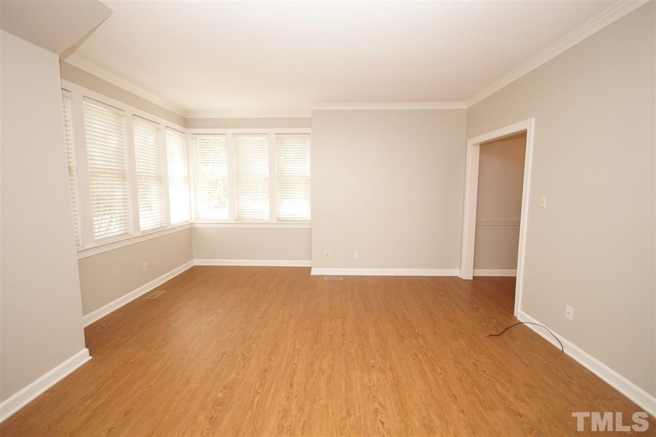 1729 Falls Church Road Raleigh, NC 27609 - Photo 5 of 25 a view of an empty room with a window and wooden floor