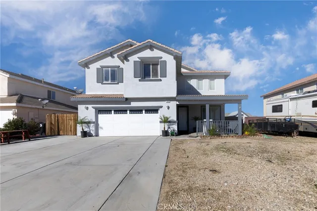 a front view of a house with a yard and car parked