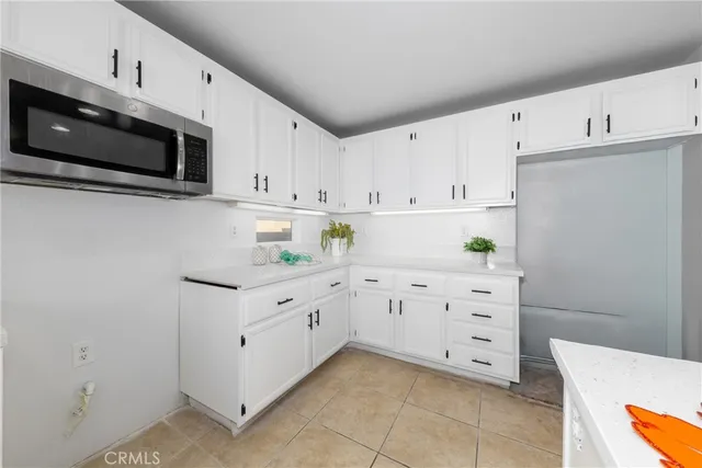 a kitchen with granite countertop white cabinets and stainless steel appliances