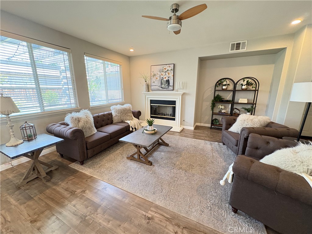 39707 Cambridge Place Temecula, CA 92591 - Photo 27 of 75 a living room with furniture a fireplace and a large window