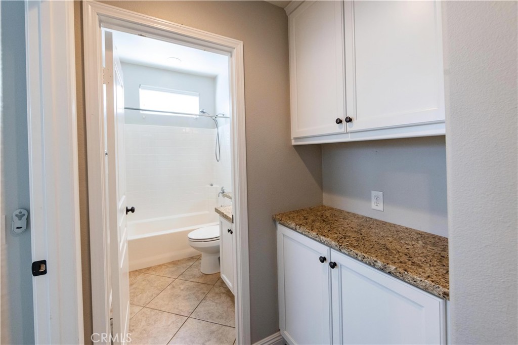 39707 Cambridge Place Temecula, CA 92591 - Photo 42 of 75 a bathroom with a granite countertop sink and toilet