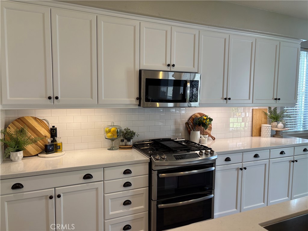39707 Cambridge Place Temecula, CA 92591 - Photo 9 of 75 a kitchen with white cabinets and appliances