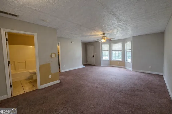 an empty room with windows and bathroom view