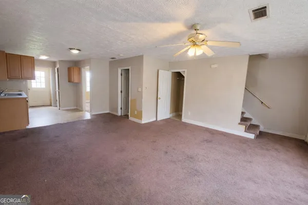 a view of a livingroom with a ceiling fan and window