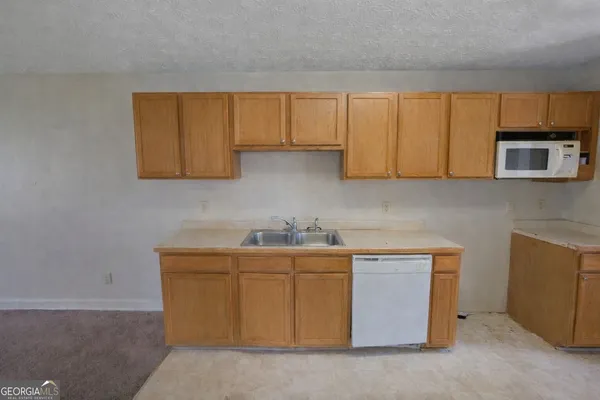 a kitchen with stainless steel appliances granite countertop a sink stove and microwave
