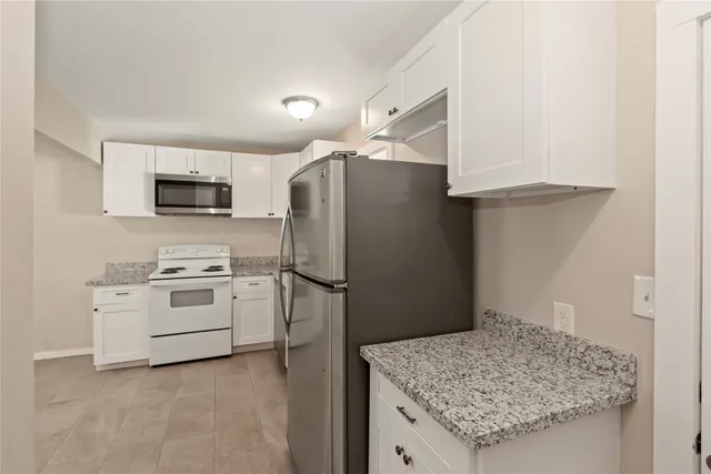 a kitchen with stainless steel appliances white cabinets and a refrigerator