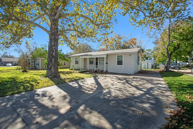 a view of a house with backyard and a tree