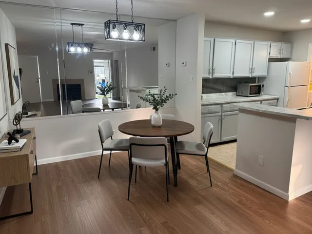 a view of a dining room with furniture a chandelier and wooden floor