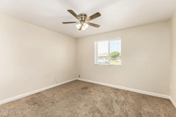 an empty room with a window and a ceiling fan