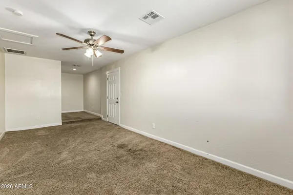 an empty room with a fan and a fan