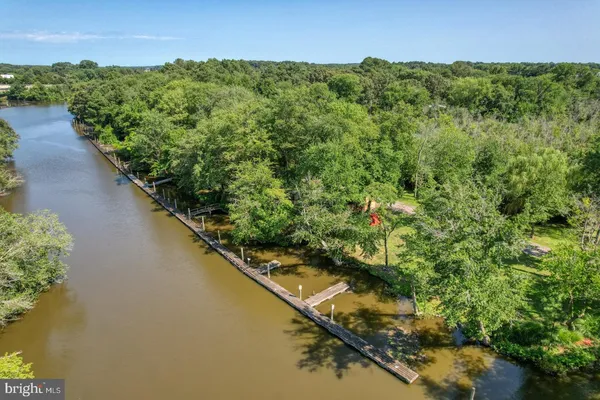 a view of a house with a yard next to a lake