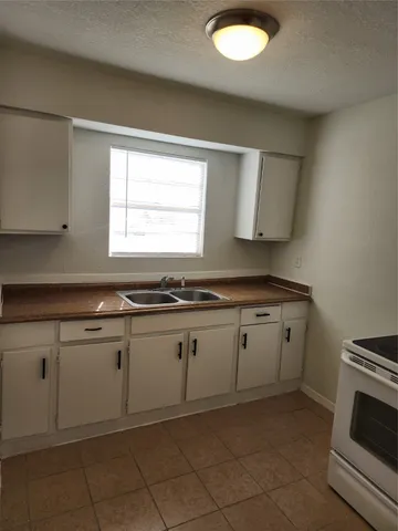 a kitchen with granite countertop white cabinets and a sink