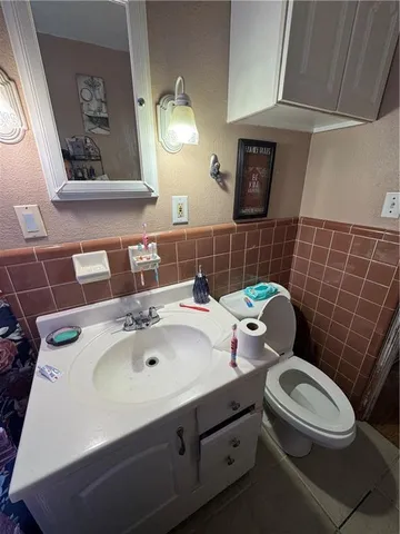 a bathroom with a sink a toilet and mirror