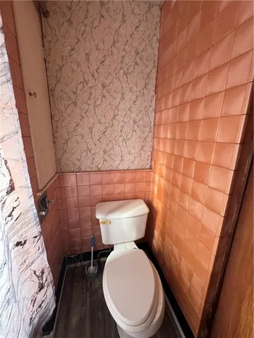a white toilet sitting next to a small bathroom