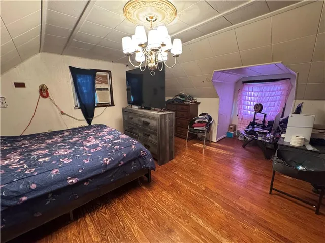 a bedroom with a bed dresser and a window