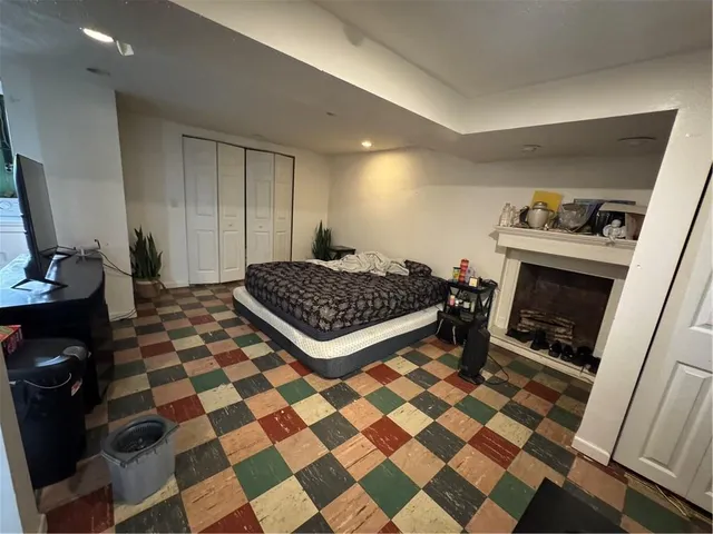 a living room with a black white checkered floor with couches chair and a coffee table