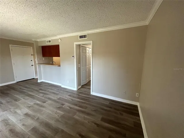a view of empty room with wooden floor
