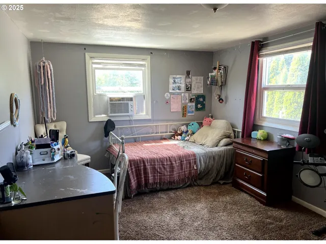 a bedroom with a bed window and table