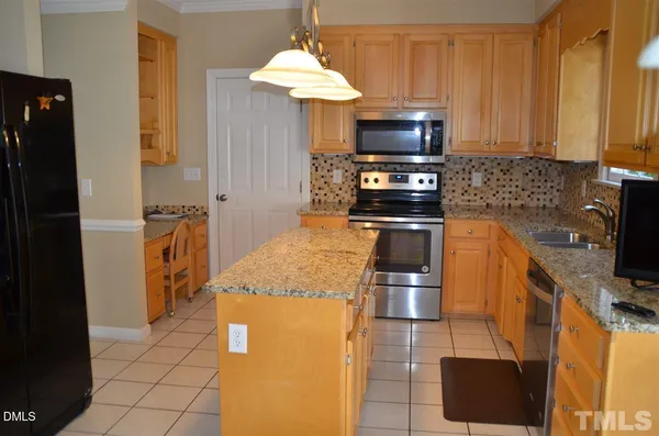 a kitchen with granite countertop a stove and a microwave