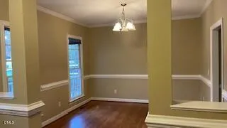 a view of a livingroom with wooden floor and a large mirror