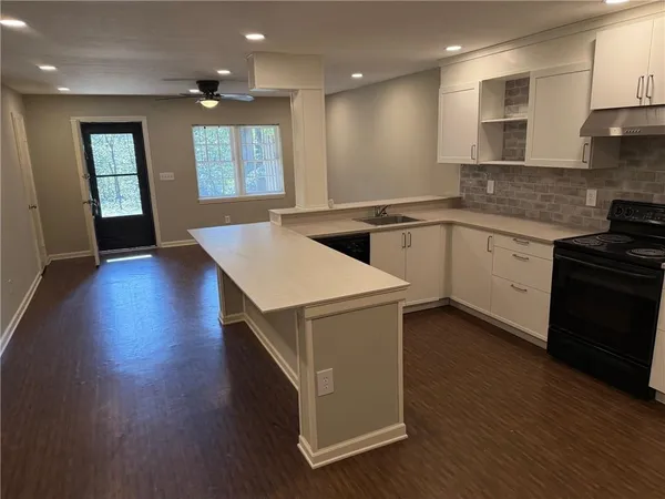 a kitchen with cabinets wooden floor and a sink