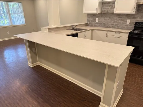 a kitchen with a sink cabinets and wooden floor