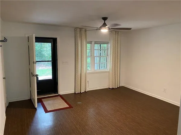 an empty room with wooden floor and windows