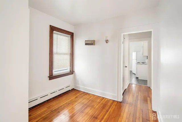 an empty room with wooden floor and a window