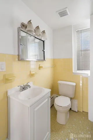 a bathroom with a sink a toilet and a mirror