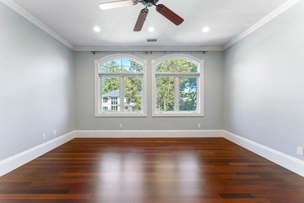 14 Cottonwood Road Newton, MA 02459 - Photo 25 of 40 an empty room with wooden floor ceiling fan and windows