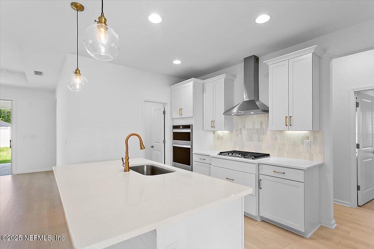 107 Crew Ct Street St. Augustine, FL 32092 - Photo 8 of 31 a kitchen with kitchen island a stove a sink and a refrigerator