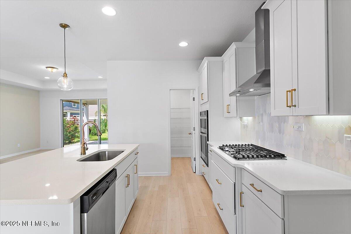 107 Crew Ct Street St. Augustine, FL 32092 - Photo 9 of 31 a kitchen with kitchen island stainless steel appliances a sink stove and refrigerator
