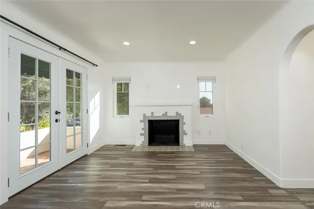a view of a livingroom with wooden floor and a fireplace