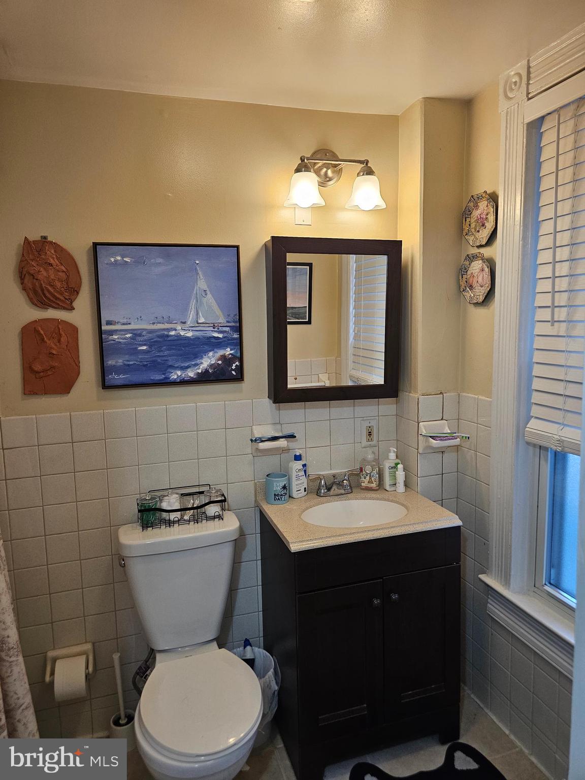 5017 Roland Avenue Baltimore, MD 21210 - Photo 14 of 35 a bathroom with a toilet sink and mirror