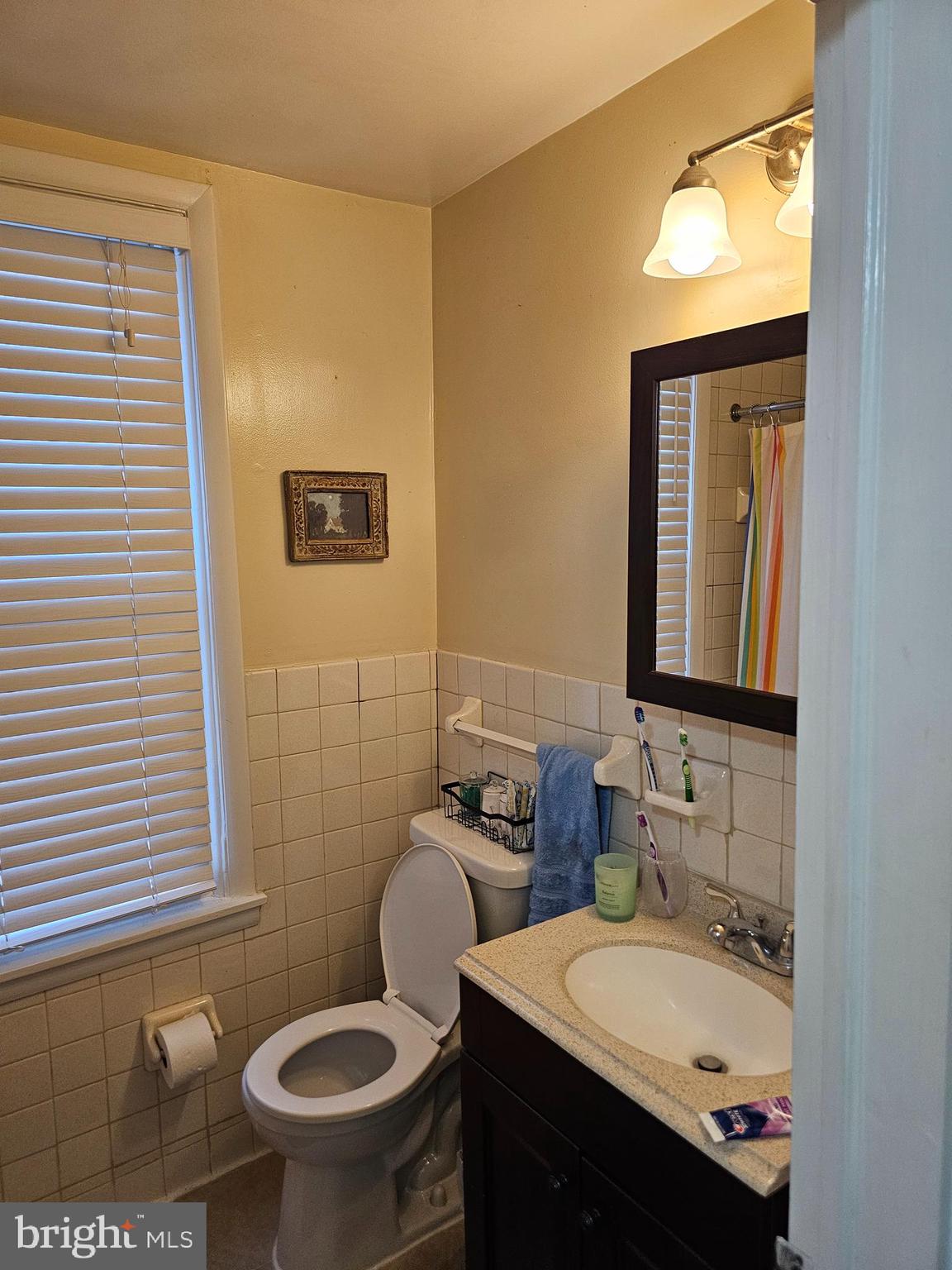 5017 Roland Avenue Baltimore, MD 21210 - Photo 16 of 35 a bathroom with a granite countertop toilet sink and mirror