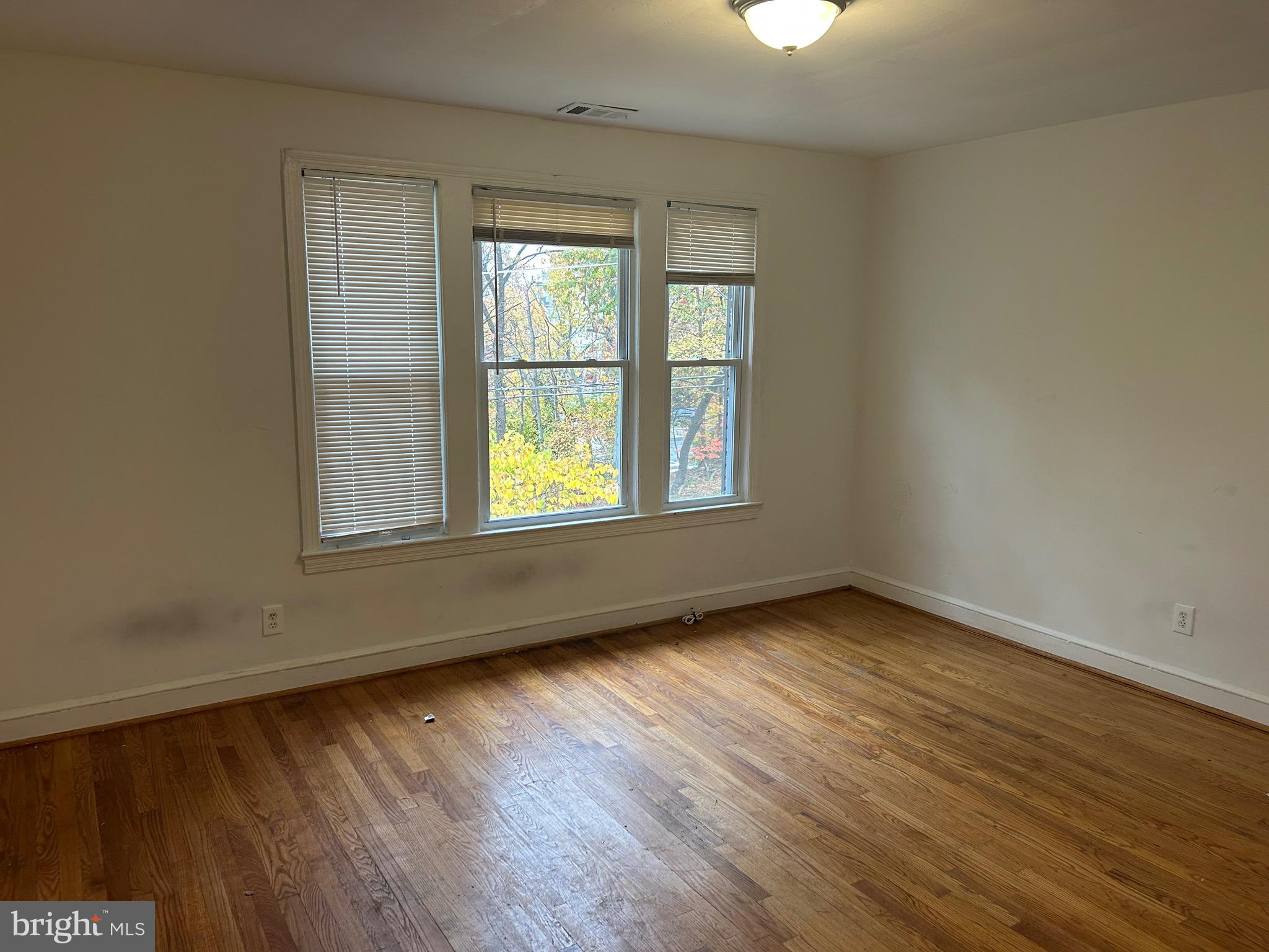 331 Parkland Place Southeast Washington, DC 20032 - Photo 4 of 8 an empty room with wooden floor and windows
