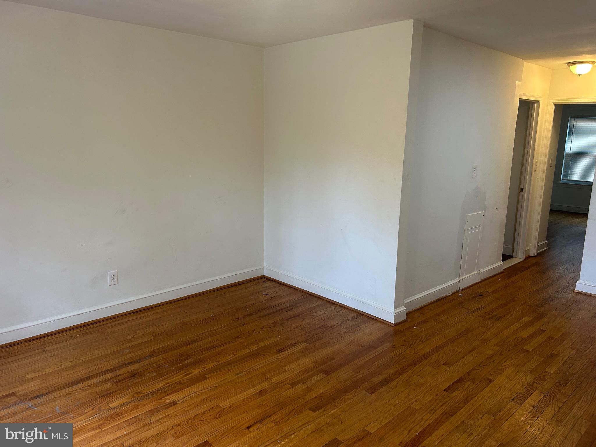 331 Parkland Place Southeast Washington, DC 20032 - Photo 5 of 8 a view of an empty room with wooden floor and a window