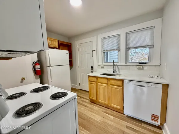 a kitchen with a sink a refrigerator and white cabinets