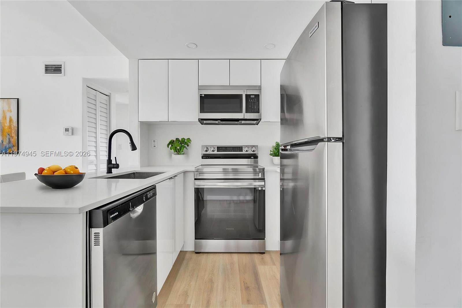 620 Southwest 10th Street, Unit 204 Miami, FL 33130 - Photo 2 of 22 a kitchen with white cabinets and stainless steel appliances