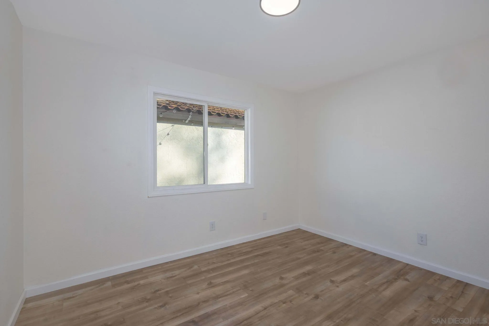 4733 Dalea Place Oceanside, CA 92057 - Photo 16 of 30 an empty room with wooden floor and windows