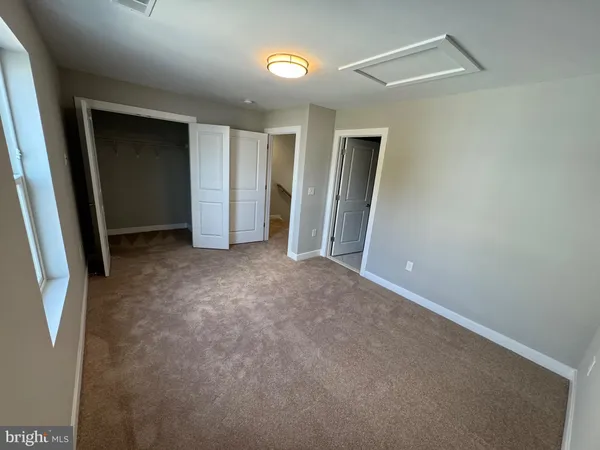 an empty room with closet and mirror