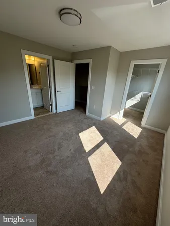 a view of a big room with wooden floor and windows