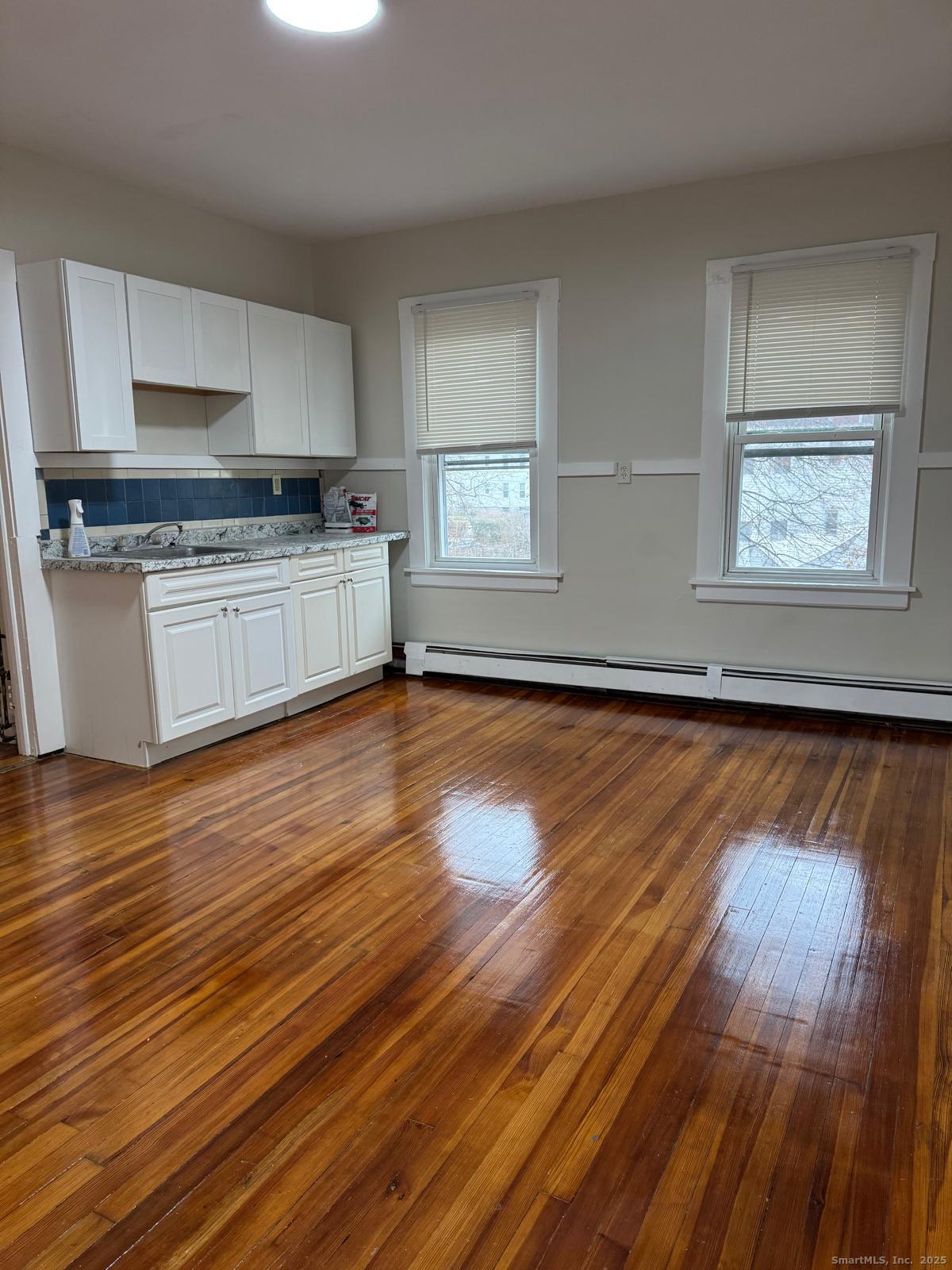 328 Chapman Street New Britain, CT 06051 - Photo 2 of 8 a kitchen with granite countertop wooden floors stainless steel appliances and cabinets