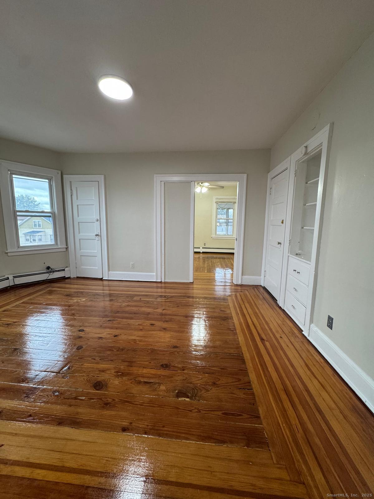328 Chapman Street New Britain, CT 06051 - Photo 5 of 8 a view of empty room with window and wooden floor