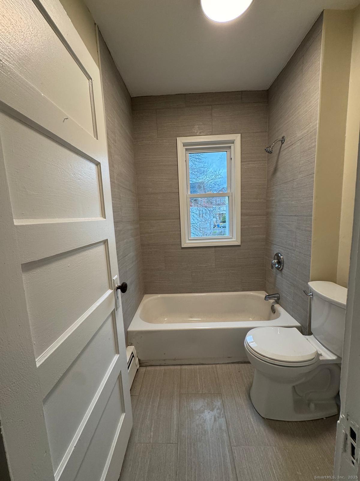 328 Chapman Street New Britain, CT 06051 - Photo 8 of 8 a bathroom with a white tub shower and toilet