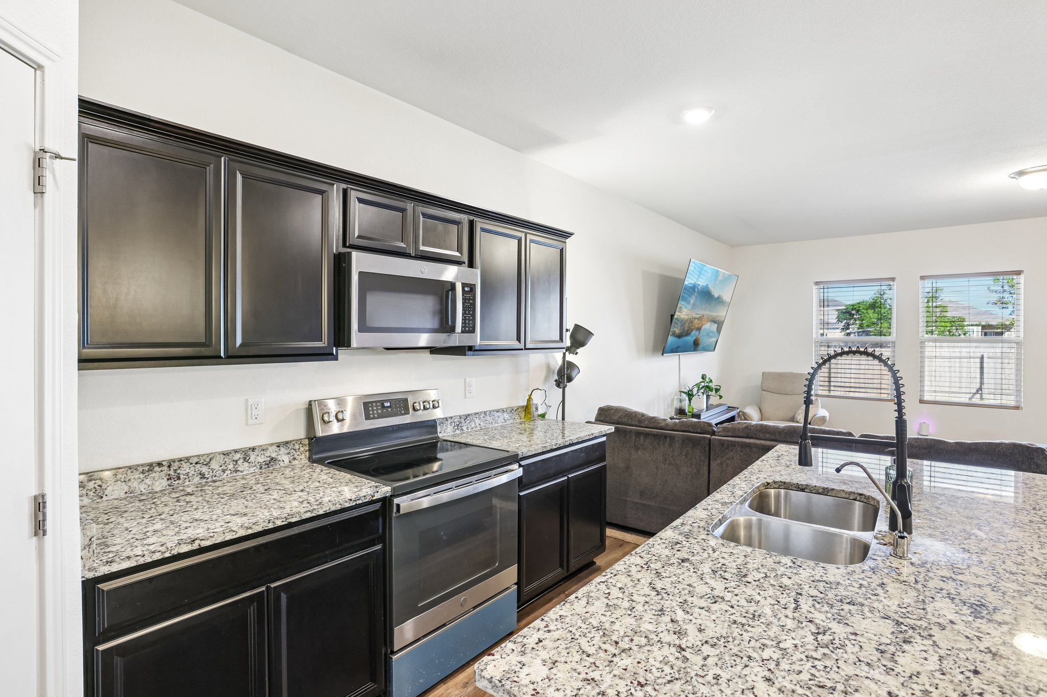 19105 Mike Mansfield Road Manor, TX 78653 - Photo 5 of 28 a kitchen with stainless steel appliances granite countertop a sink stove and cabinets